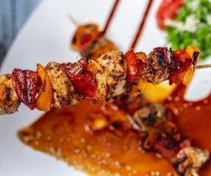 top-view-chicken-skewers-grilled-chicken-fillet-with-red-yellow-peppers-seasoning-sauce-sesame-seeds-plate_141793-3977